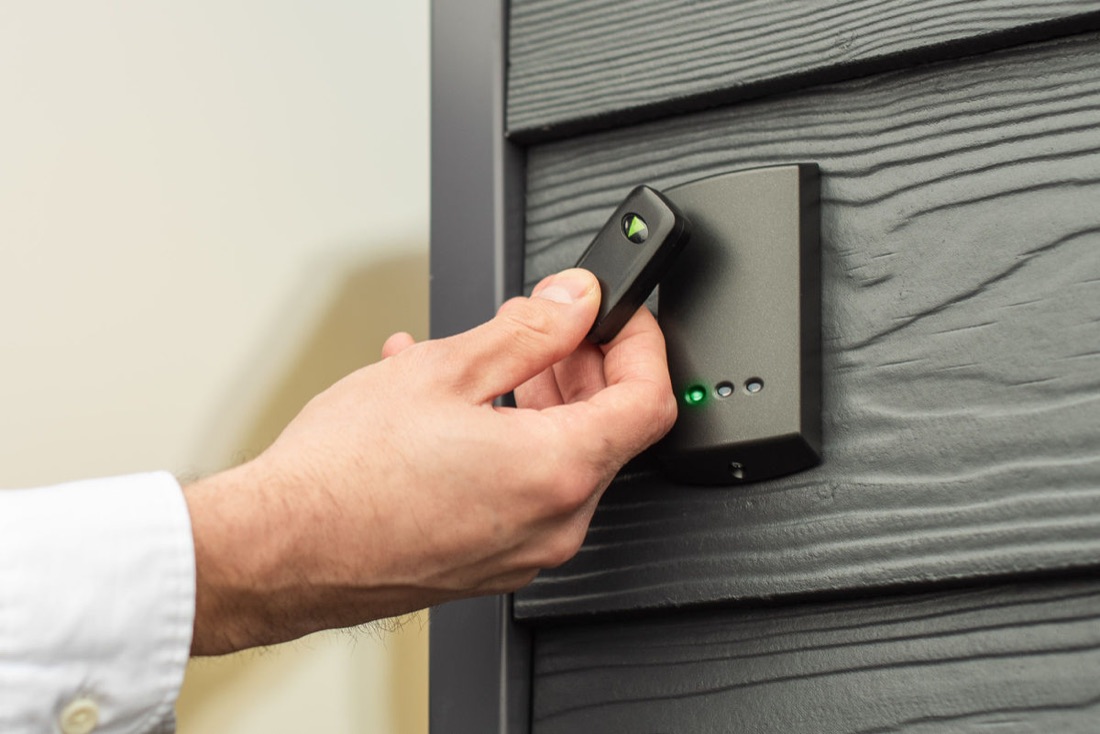 Hand holding a fob to a door reader